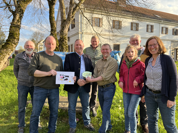 Gruppenbild mit acht Personen bei symbolischer Geldübergabe