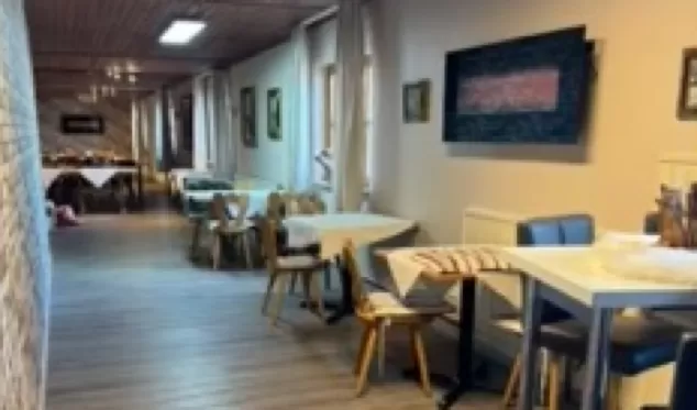 Sitzgelegenheiten mit Tischen und Stühlen auf Dielenboden