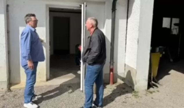 zwei Personen unterhalten sich in einer Hausecke